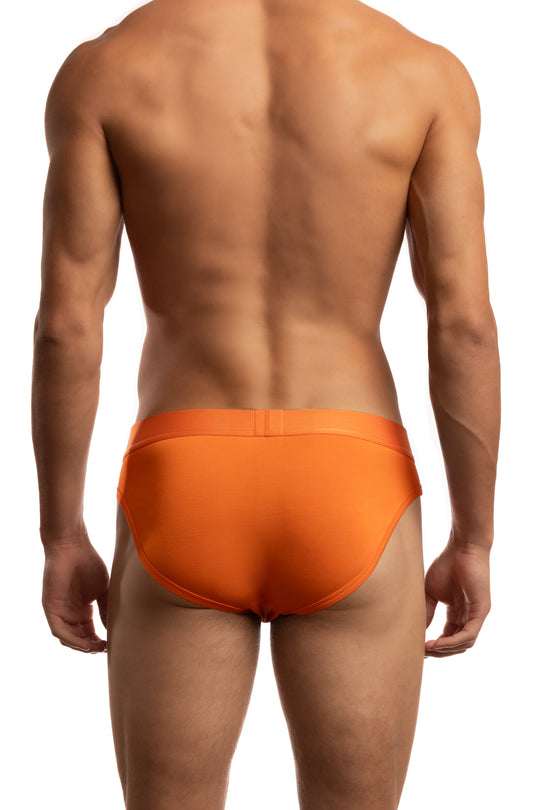 Shirtless man standing in front of a white background wearing a pair of Jack Adams Bamboo Briefs in orange (back view)