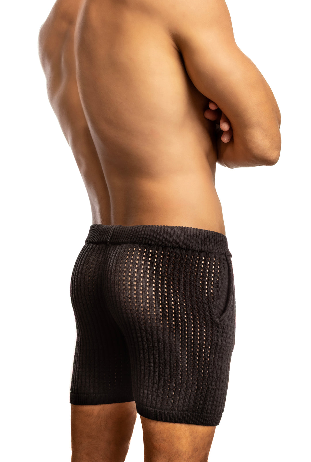 Shirtless man standing in front of a white background wearing a pair of Jack Adams Roddy Crochet Knit Shorts in black (rear view)