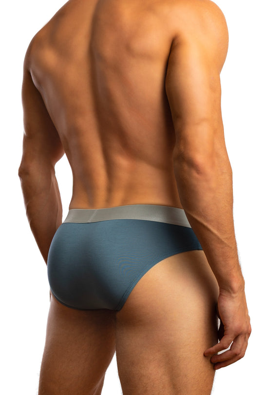 Shirtless man standing in front of a white background wearing a pair of Jack Adams Natural Fit Modal Briefs in teal (back view)